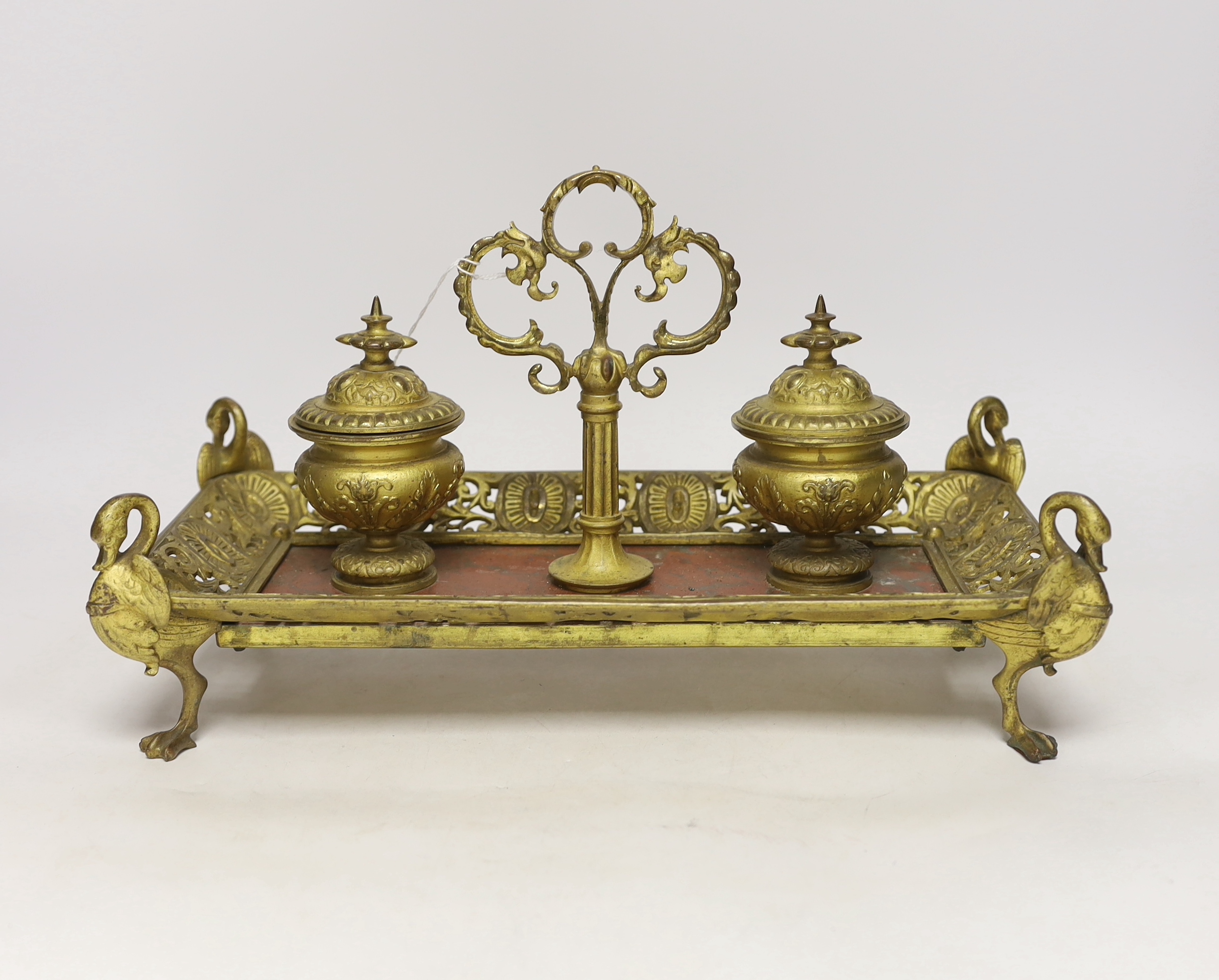 An ormolu inkstand with rouge marble base raised on four feet in the form of swans, 36cm wide
